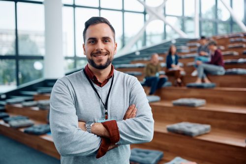 Confident public speaker during business conference in convention center looking at camera. Happy businessman with arms crossed attending an education event in convention center and looking at camera.